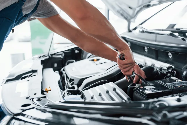 Mechanic working on a car battery terminal